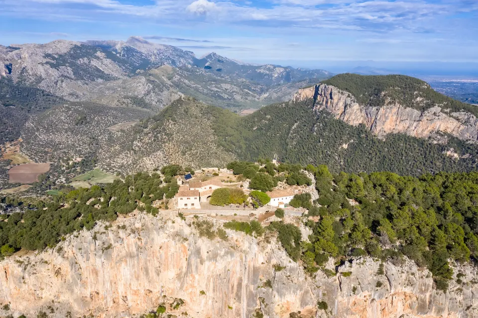 Luftfoto af borgruinen Castell d'Alaró på klippetoppen med Tramuntana-bjergene bagved