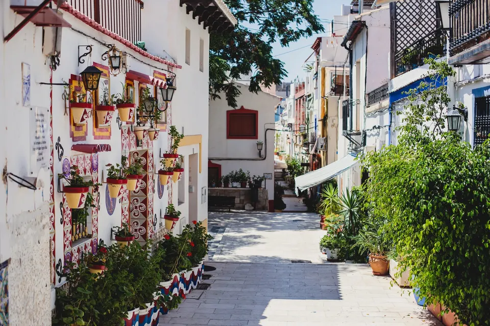 Smal gade med blomsterkrukker i den gamle bydel Santa Cruz i Alicante