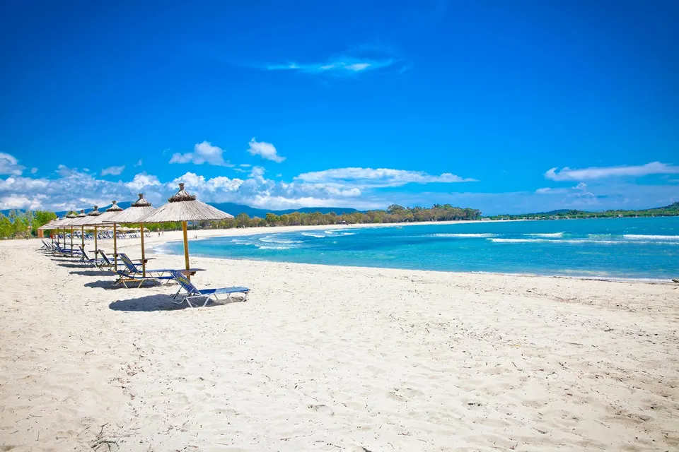 Sandstranden i Ammoudia med parasoller