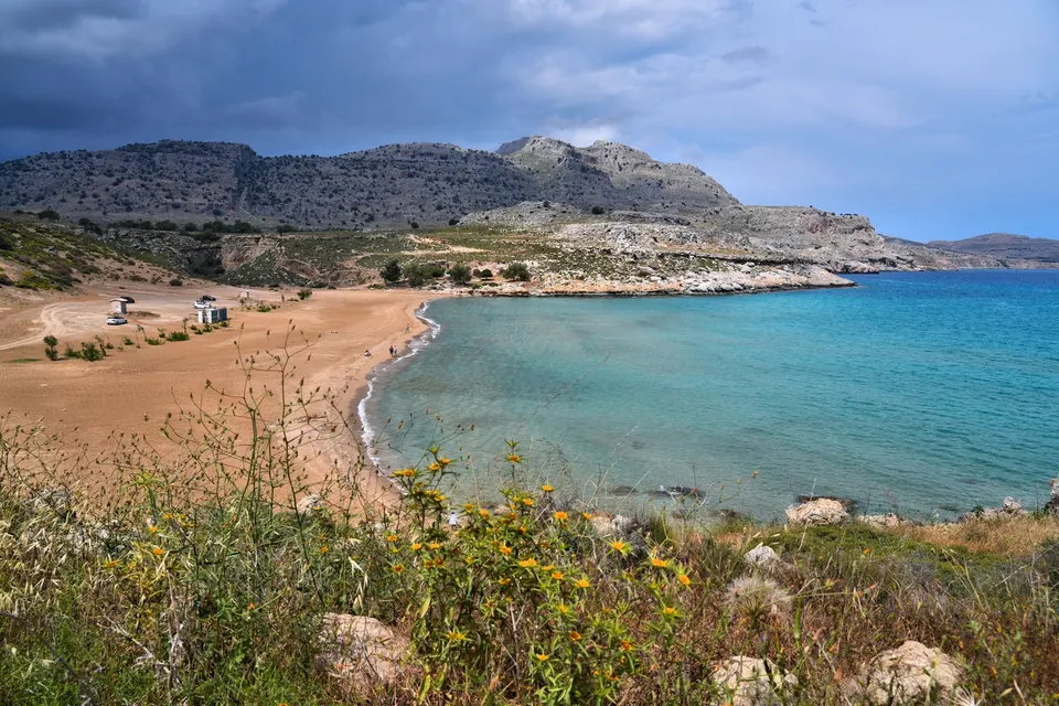Agia Agathi-stranden ved Archangelos med bjerge og grøn bevoksning under overskyet himmel