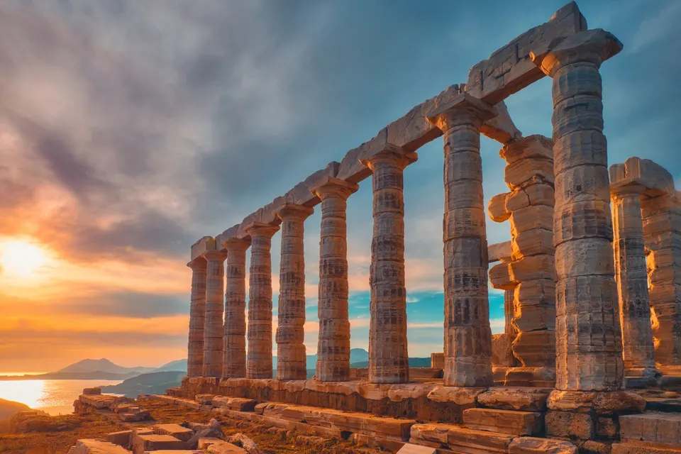 Poseidon-templet ved Kap Sounion i gyldent solnedgangslys med havet bagved