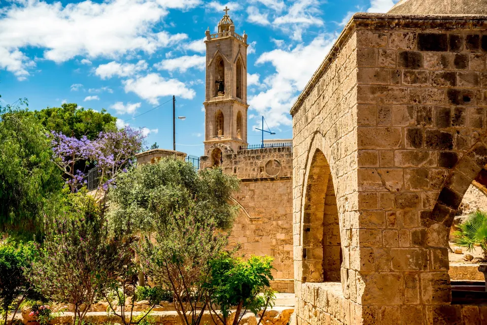 Klostret i Ayia Napa med klokketårnet og blomstrende jacaranda