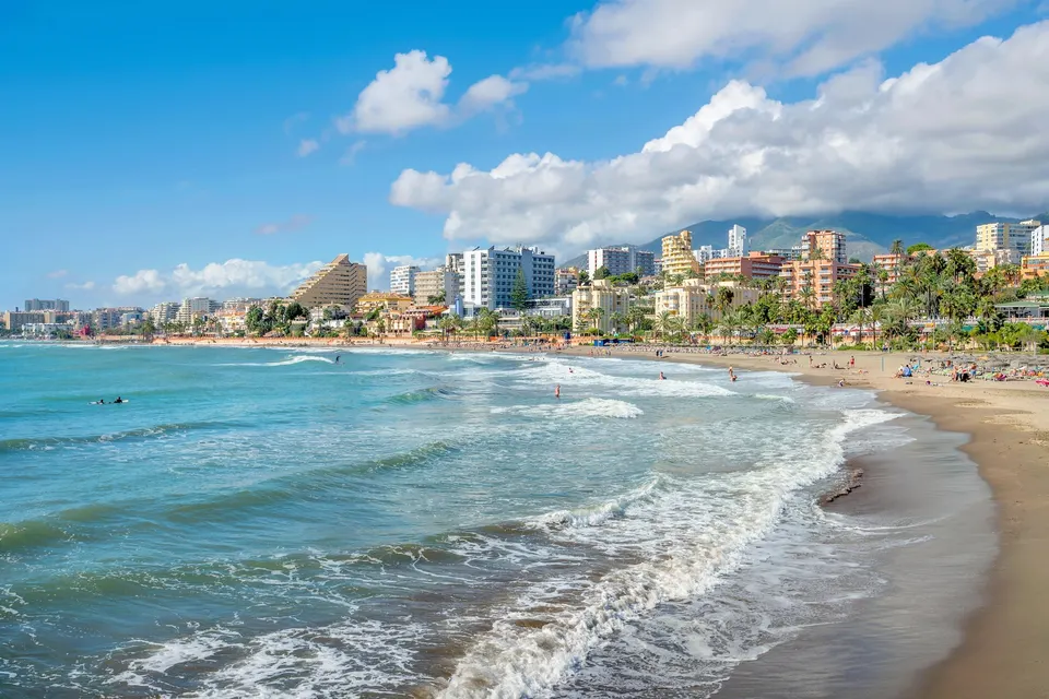 Stranden i Benalmádena med bølger og hoteller langs kysten