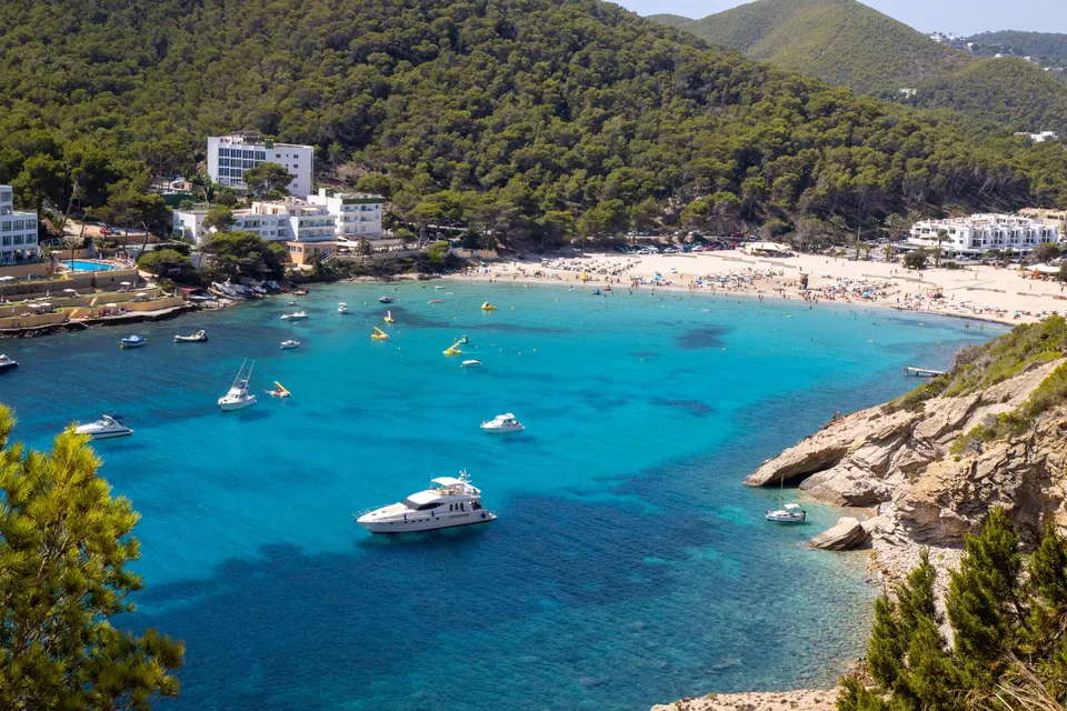 Bugten i Cala Llonga med både og stranden inderst