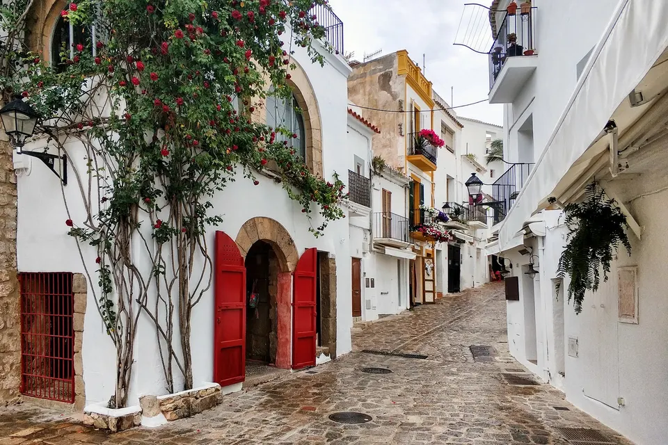 Brostensgade med blomstrende slyngplanter i den gamle bydel i Ibiza by