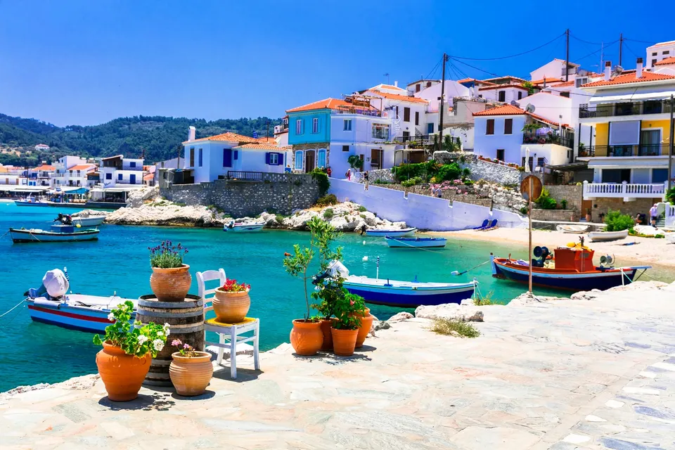 Krukker med planter og fiskerbåde ved kajen i Kokkari på Samos
