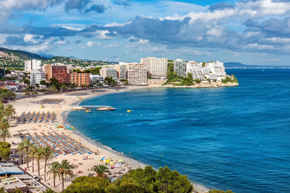 Magalufs brede sandstrand og bugt med hoteller langs kysten på en solrig dag