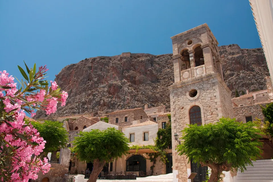 Torvet i den gamle by i Monemvasia med klokketårn og klippen bagved