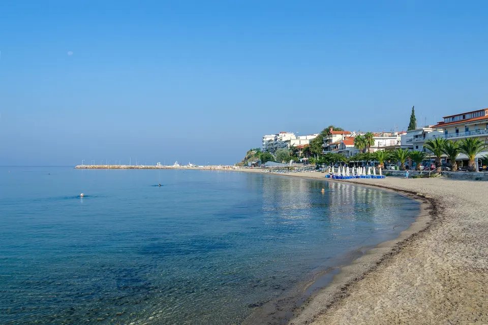 Morgen på den buede strand i Nea Kallikratia med byens huse