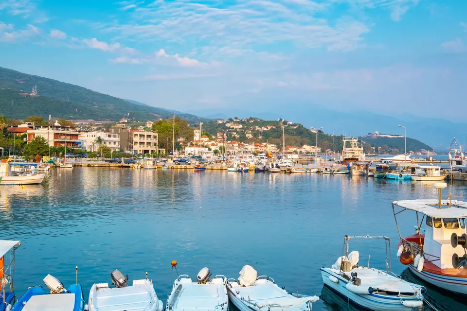 Den livlige havn i Platamonas med fiskerbåde og byens huse langs vandet