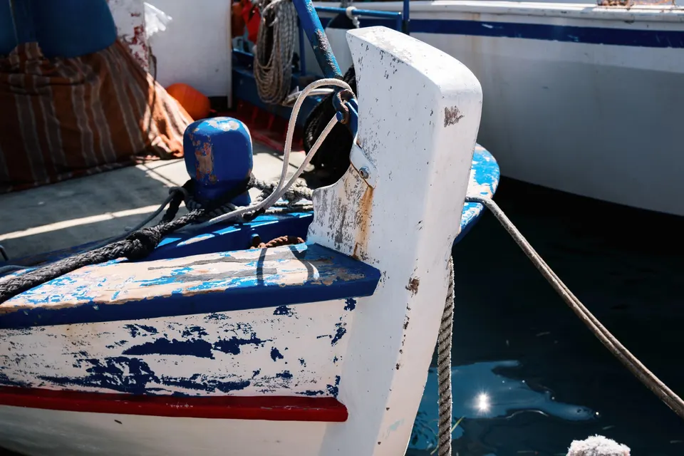 Slidt blå og hvid træstævn på en traditionel fiskerbåd