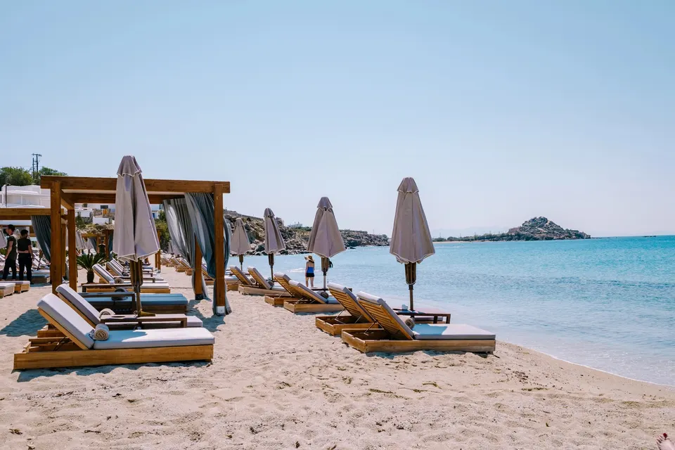 Solsenge og parasoller på sandet ved strandhotellet på Platis Gialos