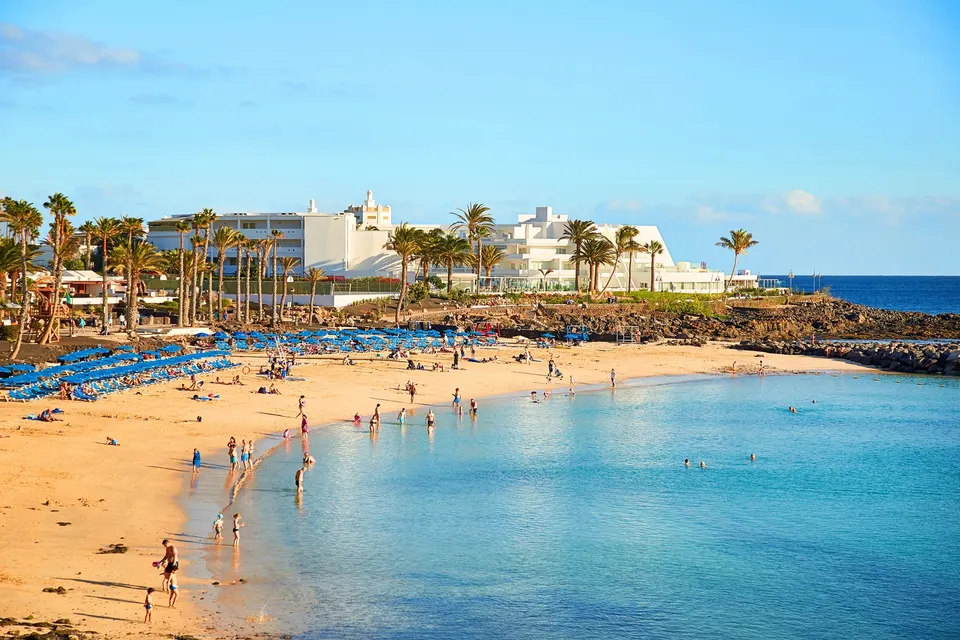 Playa Flamingo i Playa Blanca med badende i det lavvandede turkise vand