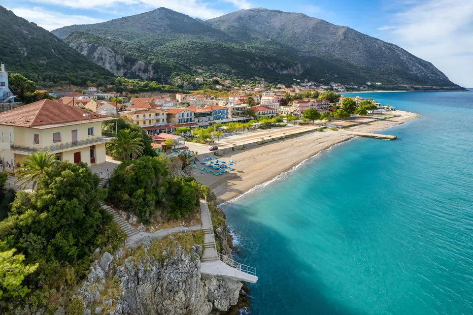 Luftfoto af byen og stranden i Poros med turkis vand