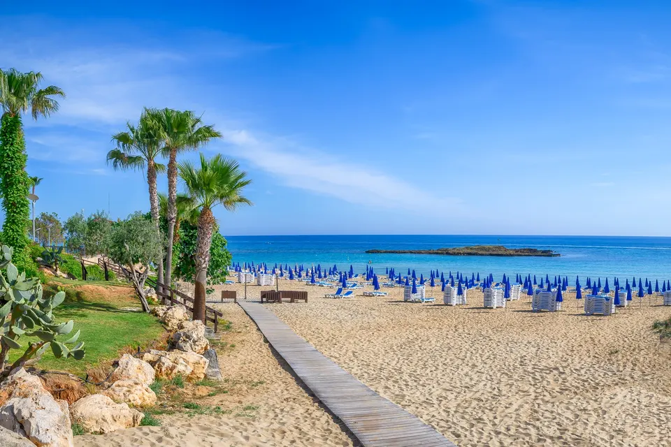 Stranden i Fig Tree Bay med parasoller og den lille ø ude i bugten