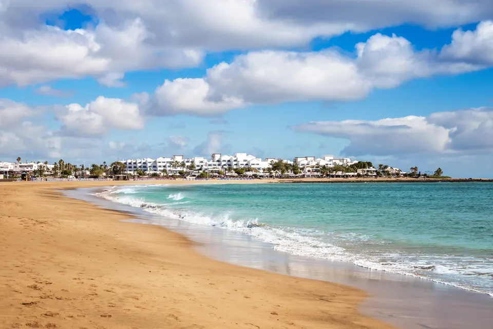 Playa de los Pocillos i Puerto del Carmen med lyst sand og hvide hoteller