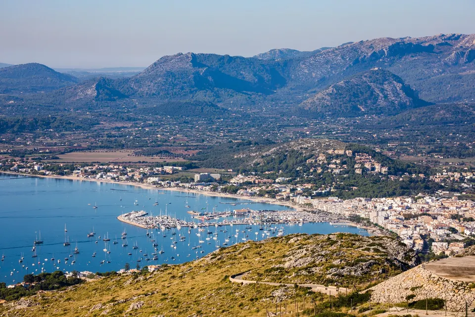 Udsigt over Puerto Pollensa med lystbådehavnen, bugten og bjergene bag byen, set fra Es Colomer