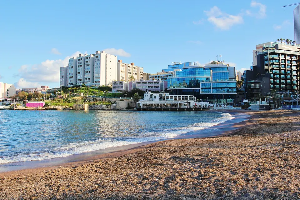 Sandstranden i St. George's Bay i St. Julian's med det klare vand