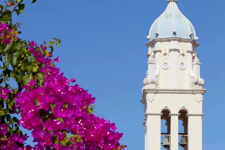 Klokketårnet ved Agios Nikolaos-kirken i Svoronata med lilla bougainvillea