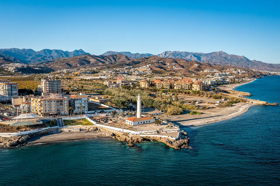 Fyrtårnet og stranden i Torrox Costa med bjergene bag